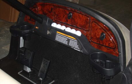 golf cart front interior showing dashboard golf ball holder and compartments and foot pedals
